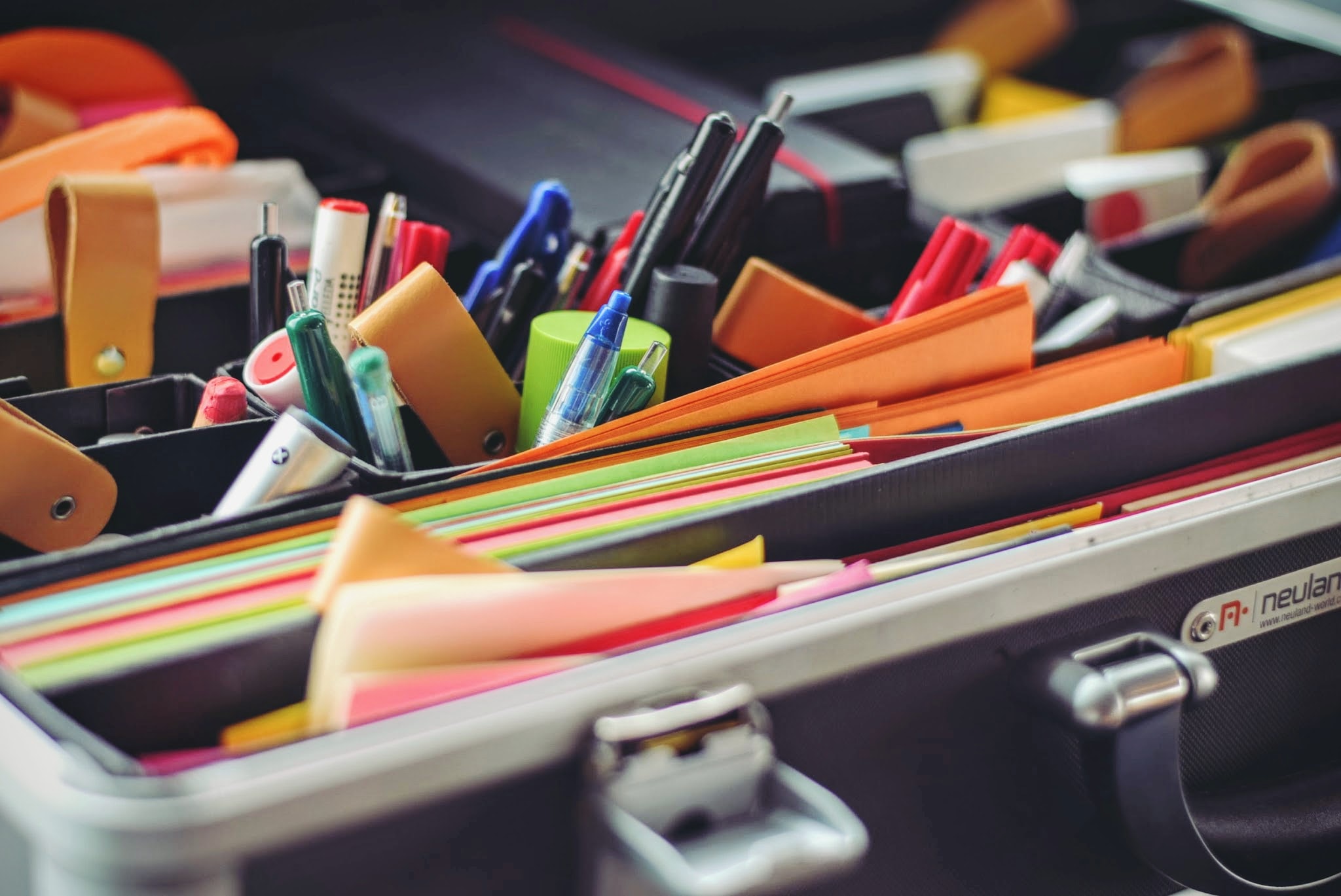 Ensemble de stylos et de papiers dans une malette de l'agence d'identité visuelle à Reims et Paris